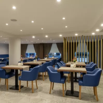 salle de restaurant avec tables et fauteuils bleus