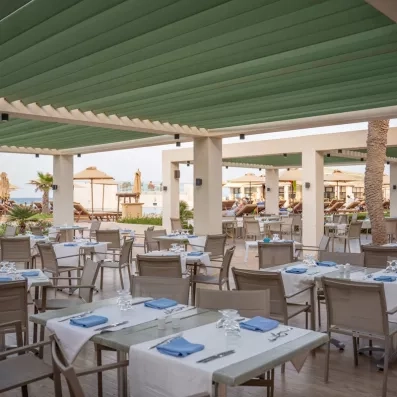 Terrasse ombragée du restaurant Kalypso à l'hôtel Ulysse Djerba offrant une ambiance conviviale en extérieur.