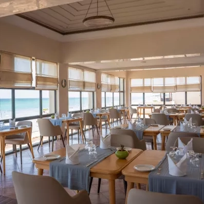 Salle de restaurant avec vue panoramique sur la mer Méditerranée à l'hôtel Ulysse à Djerba.