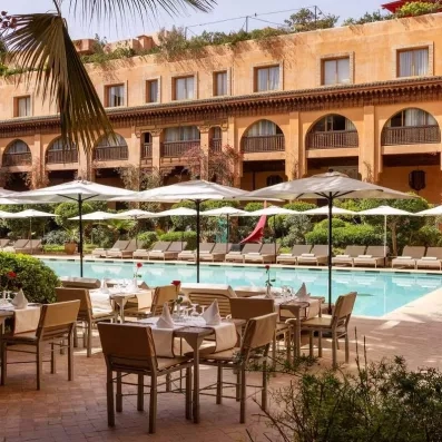 restaurant sur la terrasse avec des tables et des chaises donnants sur la piscine