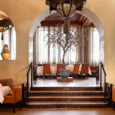 restaurant de l'hôtel avec grande table au milieu avec un olivier pour décorer