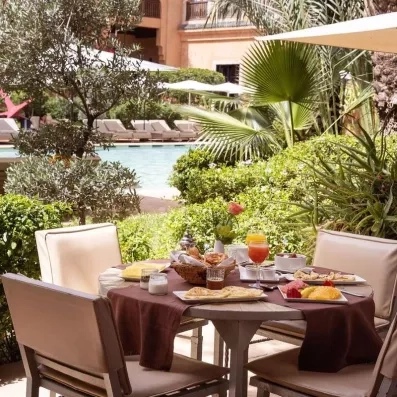 table dressée avec des chaises sur la terrasse sur la piscine