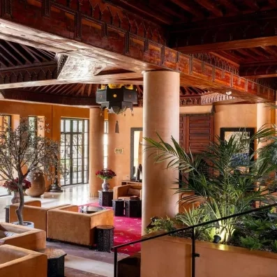 Lobby bar de l'hôtel avec un toit sculpté en bois et des plantes extérieurs