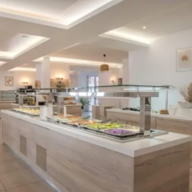 Buffet de l'hôtel varié, grande salle blanche épurée, crudités, salades, tomates