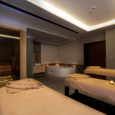 Cabine de massage tamisée avec bougies et baignoire balnéo au spa du Mondi Club Hurghada.