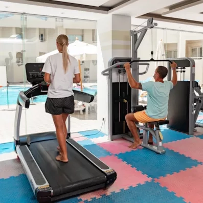 Salle de sport lumineuse avec vue sur piscine pour des vacances actives à Hurghada, Égypte.