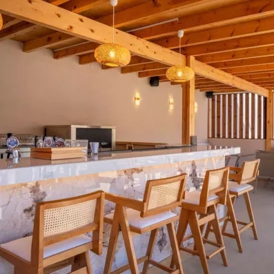 bar, chaises en bois, lampes rondes, poutres en bois apparentes, bières