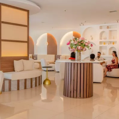 réception de l'hôtel avec des fauteuils blancs et une table ronde au milieu avec un bouquet de fleur