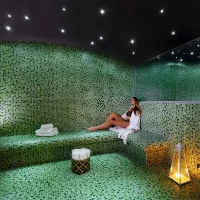 Hammam vert, femme qui profite du hammam, grand miroir en hauteur, serviettes, lampe