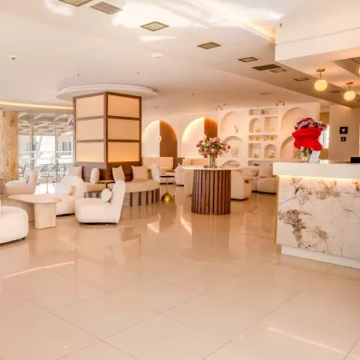 réception de l'hôtel avec des fauteuils blancs et un comptoir d'accueil 