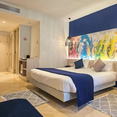 Suite spacieuse et lumineuse du Mondi Club One Resort Jockey à Monastir, avec coin bureau et décoration murale colorée.