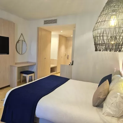 Aménagement intérieur d'une chambre au Mondi Club One Resort Jockey Monastir, incluant bureau, miroir et rangements pour les vacances.