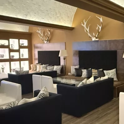 Salon cosy avec banquettes élégantes, panneaux bois et décoration murale raffinée