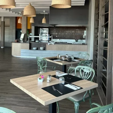 Un espace de restauration moderne avec des tables en bois clair et des chaises.