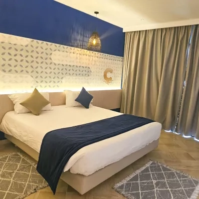 Chambre double élégante au Mondi Club One Resort Jockey Monastir avec décoration bleue et luminaires en osier