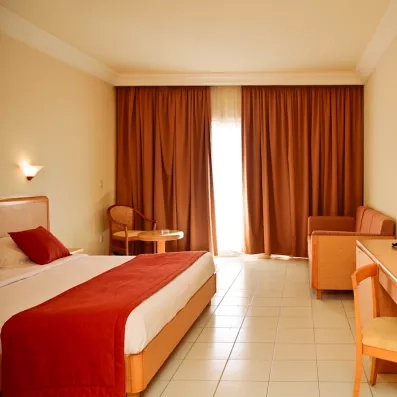 vue intérieure de la chambre double avec petit canapé et chaise en fond 