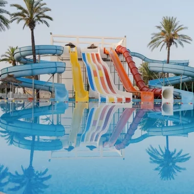 Grand parc aquatique avec toboggans colorés et piscine extérieure au complexe hôtelier Mondi Club One Resort Jockey à Monastir.