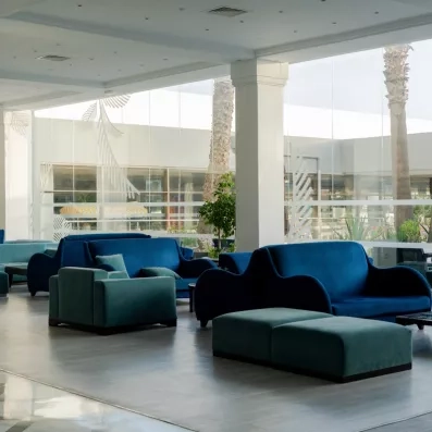 Lobby moderne et spacieux avec canapés bleus confortables au Mondi Club One Resort Jockey, hôtel 4 étoiles à Monastir.