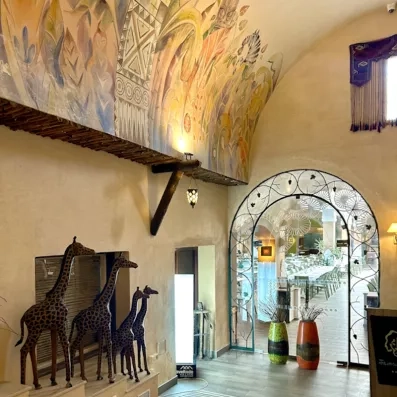 Entrée artistique décorée de fresques colorées, sculptures animales et arche ornée