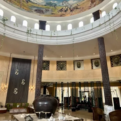 Hall majestueux avec coupole peinte, colonnes décoratives et vaste espace lumineux