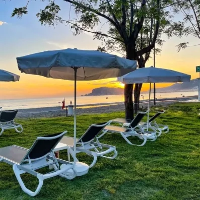 transats et parasols sur le jardin vue sur la mer
