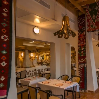 Salon oriental coloré avec service de thé traditionnel et clients profitant d’un moment convivial.