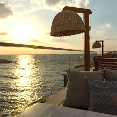 Terrasse d'un hôtel de luxe face au soleil couchant sur la mer Rouge, vacances farniente en Égypte.