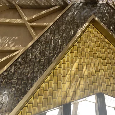 Mur orné de hiéroglyphes dorés au Grand Musée Égyptien du Caire, nouveau monument phare du tourisme égyptien.