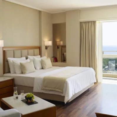 La chambre avec grand lit double avec une porte fenêtre pour la terrasse et une vue sur mer 