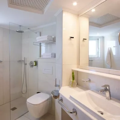 Salle de bain avec vasque en marbre, grand miroir et une douche italienne