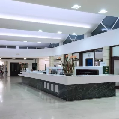 réception intérieur avec un comptoir en gris et blanc et des boutiques de souvenirs au fond