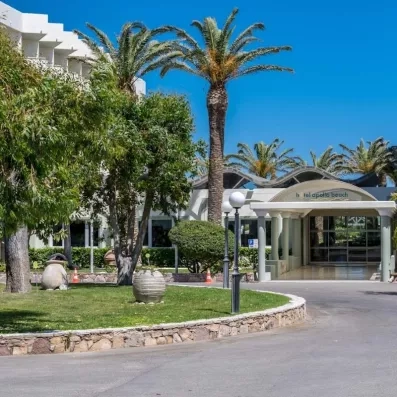 entrée extérieure de l'hôtel avec un rond-point au milieu avec de la végétation