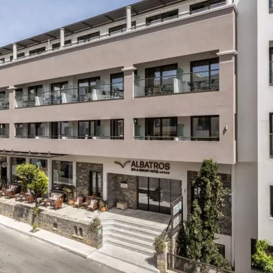 Façade de l'hôtel avec balcons des chambres et végétation à l'entrée