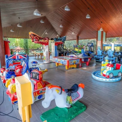 Une salle de divertissement avec des jeux d'arcade, des manèges pour enfants.