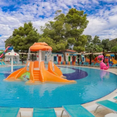 Une aire de jeux aquatiques pour enfants avec des toboggans et une fontaine.
