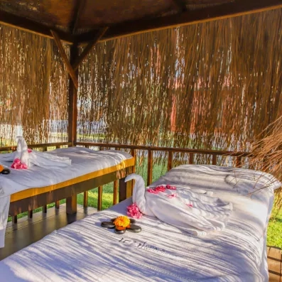 Un pavillon de massage extérieur avec deux tables apprêtées de serviettes.