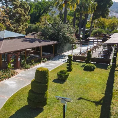 Une vue aérienne des jardins verdoyants du complexe et des terrasses ombragées.
