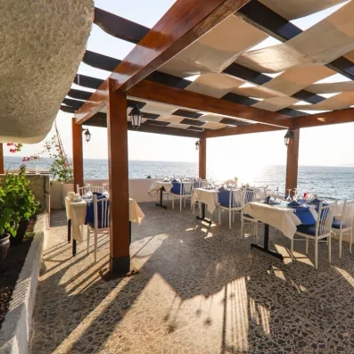 Un restaurant élégant, installé sous une pergola en bois avec une vue imprenable sur l'horizon.