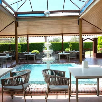 Un espace de détente serein s'ouvrant sur une fontaine centrale sous une verrière.