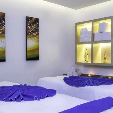 Deux tables de massages préparés avec des serviettes dans un cadre apaisant.