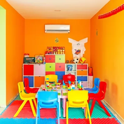 Une salle de jeux intérieure équipée de petites chaises, de tables d'activités.