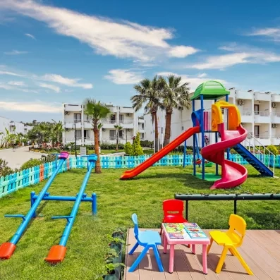 Un espace extérieur pour enfant comprenant des toboggans, des balançoires.