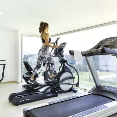 Une salle de sport lumineuse équipée de machines modernes et de tapis de course.