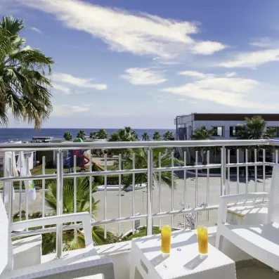 Le balcon aménagé avec une petite table, offrant une vue dégagée sur le complexe hôtelier et la mer.