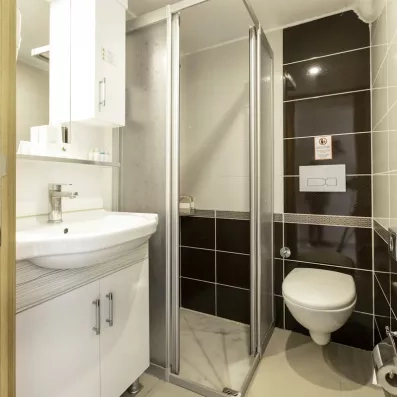 Une salle de bain équipée d'une cabine de douche et d'un lavabo blanc.