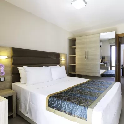 Une chambre moderne avec un lit double et une armoire intégrée avec miroir.