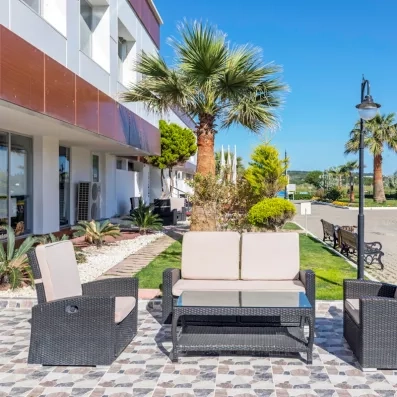 Une terrasse extérieure ensoleillée aménagée avec du mobilier de jardin.