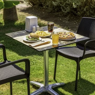 Un déjeuner décontract servi, sur une table de jardin ensoleillée.