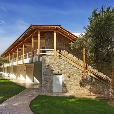 jardin et accès aux chambres par escalier extérieur en bois, façade en pierres apparentes, olivier