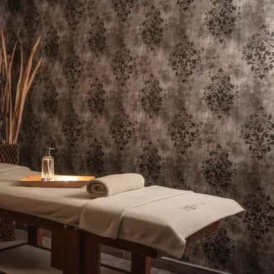 Une table de massage prête pour un soin dans une cabine élégante.